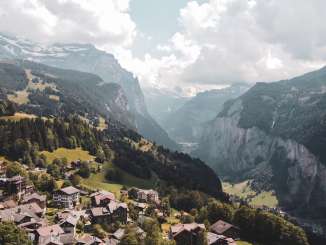 Vue sur le village de Wengen et la vallée de Lauterbrunnen en été. Le ciel est légèrement nuageux.