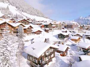 Sicht auf ein verschneites Mürren. Im Hintergrund die Strecke der Allmendhubelbahn.