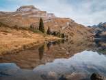 Der Engstlensee spiegelt die umliegenden Bergketten fast vollständig. Im Vordergrund liegen Steine unter der Wasseroberfläche, die Landschaft wirkt weitläufig und ruhig.