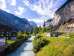 The Lütschine River flows through the village of Lauterbrunnen. The church stands next to the river, nestled between the steep cliffs of the Lauterbrunnen Valley.