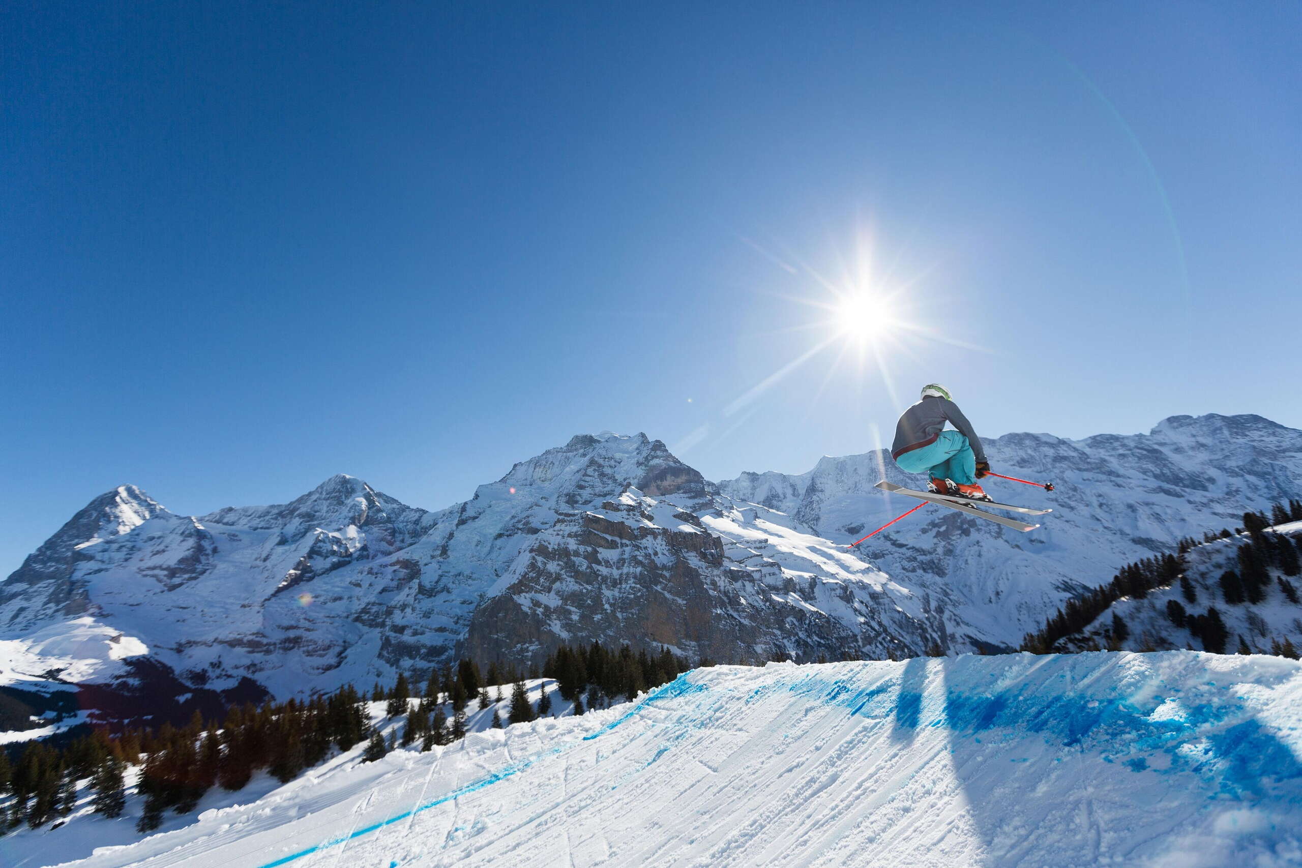 A skier on the ski cross slope in the Mürren-Schilthorn ski area. The Eiger, Mönch and Jungfrau triumvirate can be seen from afar.