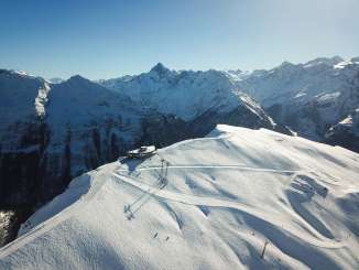 Aerial view of the mountain station and the Alpen Tower panoramic restaurant on Hasliberg in winter.