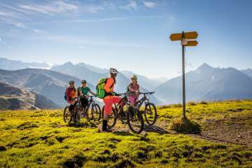 Les cyclistes regardent le panneau indicateur et profitent de la vue depuis le Hasliberg. Le panorama offre une vue estivale sur le paysage montagneux.