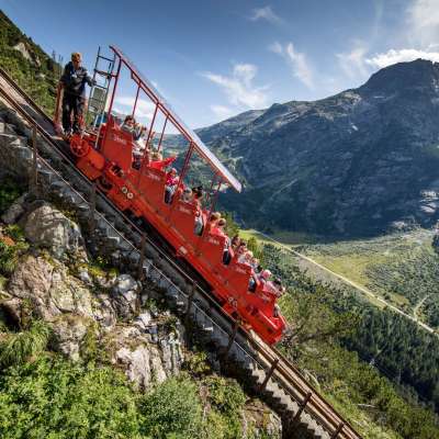 The Gelmerbahn with passengers and the train engineer, offering a great view on a sunny day.
