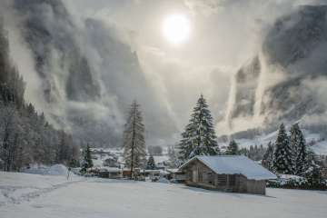 The snow-covered Lauterbrunnen Valley with mystical clouds and sunshine