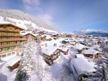 Vue sur Mürren enneigé. À l'arrière-plan, le tracé du téléphérique de l'Allmendhubel.