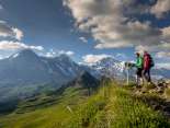 Deux randonneurs admirent la vue depuis le Männlichen sur l'Eiger, le Mönch et la Jungfrau. 