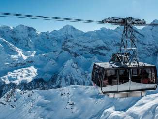 Die Schilthorn Gondel bei der Bergfahrt zur Birg. Im Hintergrund ist das verschneite Bergpanorama rund um das Gspaltenhorn zu sehen.