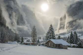 Verschneites Lauterbrunnental mit mystischen Wolken und Sonne