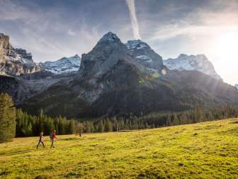 Randonnée d'automne à travers une clairière. Les randonneurs admirent le panorama montagneux de la vallée du Rosenlaui, avec ses sommets légèrement enneigés.