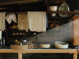 The interior of a traditional alpine cheese dairy in Grindelwald, featuring cheese cloths, cheese molds, and wooden furnishings.