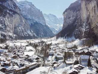 Drohnenaufnahme vom Dorf Lauterbrunnen im Winter mit Kirche und Staubbchfall.