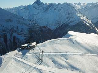 Aerial view of the mountain station and the Alpen Tower panoramic restaurant on Hasliberg in winter.