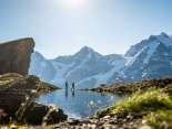 Wanderung mit Hund am Grauseeli. Das verschneite Bergpanorama mit Eiger, Mönch und Jungfrau erstreckt sich im Hintergrund.