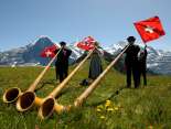 At the Mountain Spring Festival on the Männlichen, three musicians are playing the alphorn on the meadow.