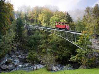 Le train rouge des chutes de Reichenbach traverse le pont pour monter jusqu'au Reichenbach.