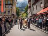 Alpabzug, Gruppe geschmückte Kühe mit Alphirten gehen auf der Dorfstrasse von Wengen. Viele Leute am Rand der Strasse welche filmen und fotografieren.