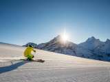 Skifahren im Skigebiet Grindelwald First. Skifahrer ziehen in schönen Schwüngen ihre Spuren durch den Schnee.