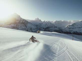 Des skieurs sur le First, sous le soleil matinal.