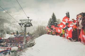 A snapshot from the Lauberhorn Race in Wengen. Swiss fans cheer on the skiers from the side of the course.